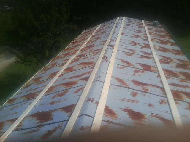 Rusted metal roof panels with new wood purlins before replacement — Storm Damage Roof Repair in Ellinwood by Roofing Brothers