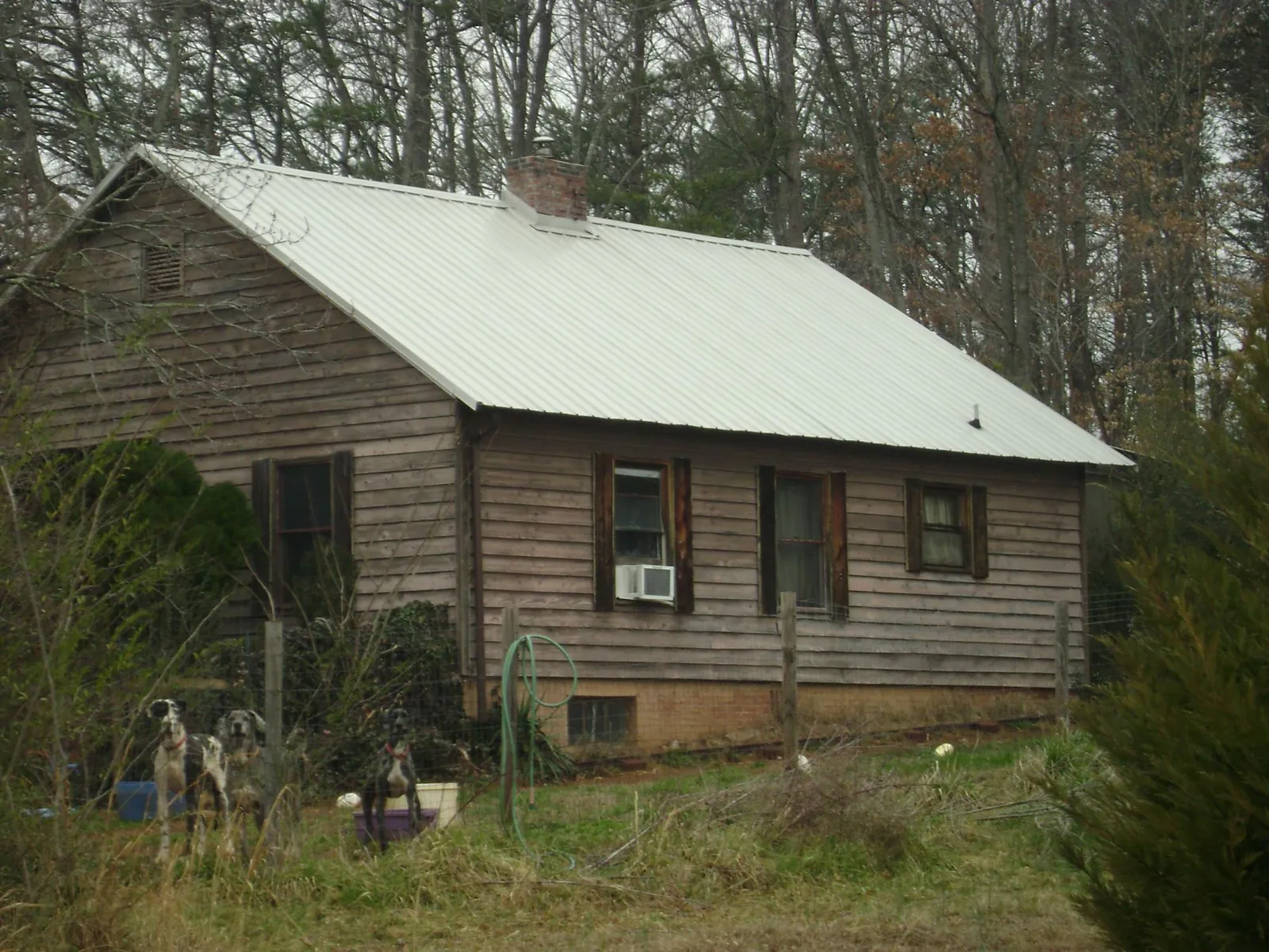 White metal roof on an old wood sided farmhouse, from a Metal Roof Installation job in Ellinwood